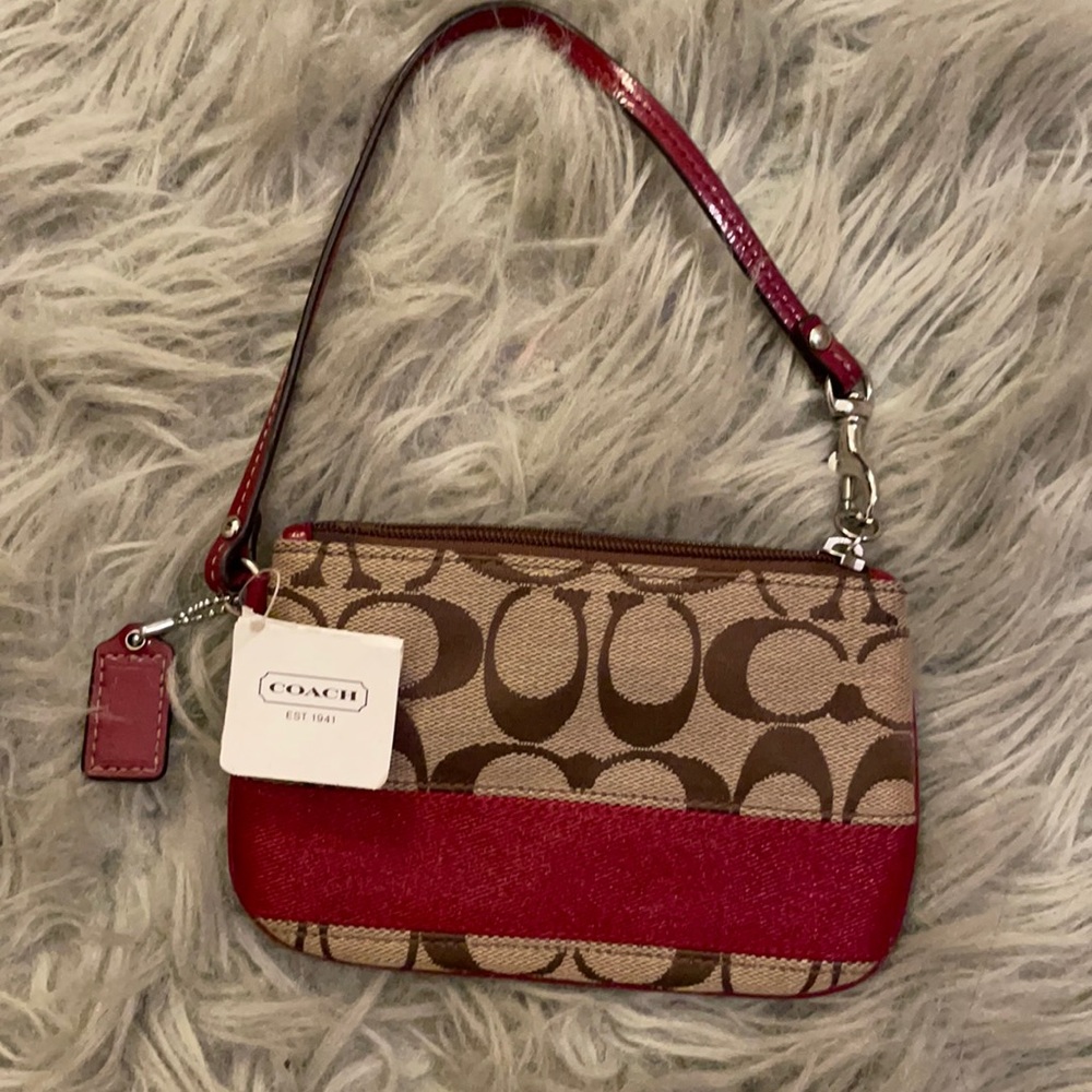 This red and tan Coach Wristlet is  for sale with tag still attached.